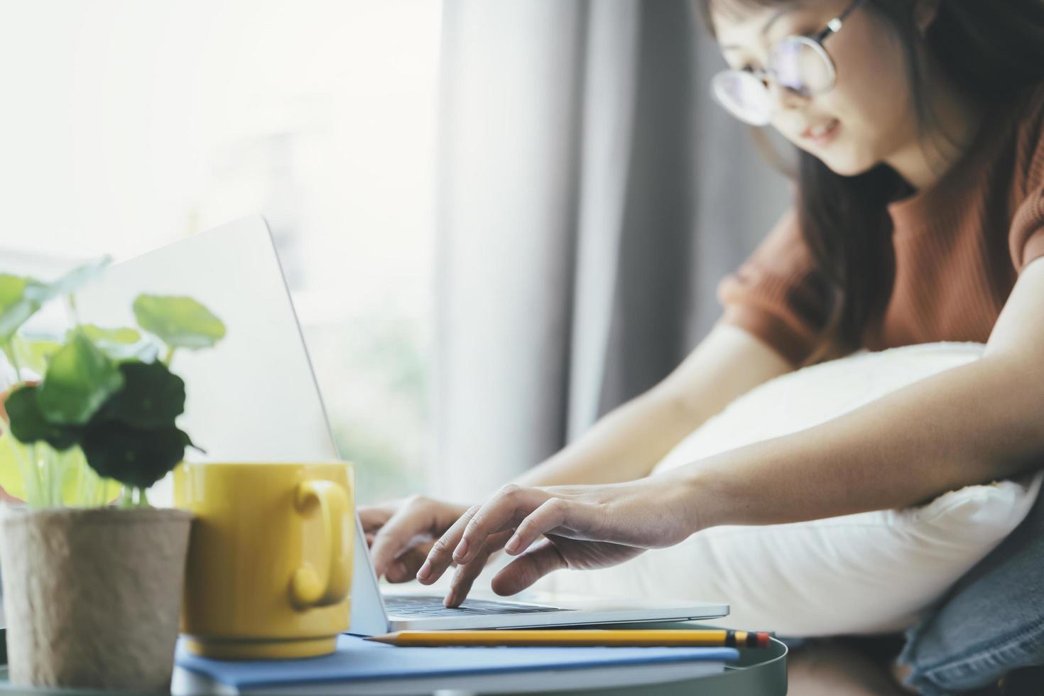 donna che digita sul computer portatile a casa foto