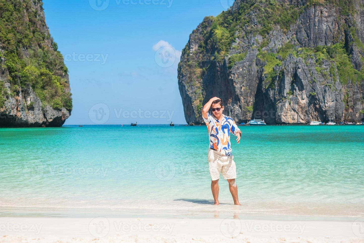 uomo turistico felice alla spiaggia della baia di maya sull'isola di phi phi, krabi, tailandia. punto di riferimento, destinazione di viaggio nel sud-est asiatico, vacanza e concetto di vacanza foto