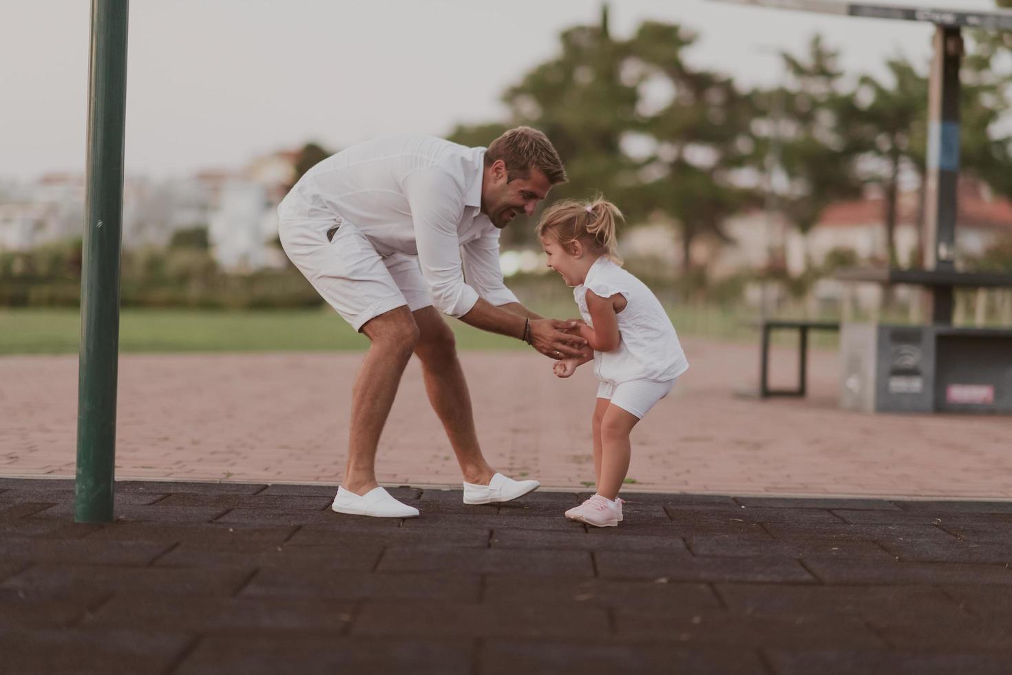 un anziano uomo nel casuale Abiti con il suo figlia spende tempo insieme nel il parco su vacanza. famiglia volta. selettivo messa a fuoco foto