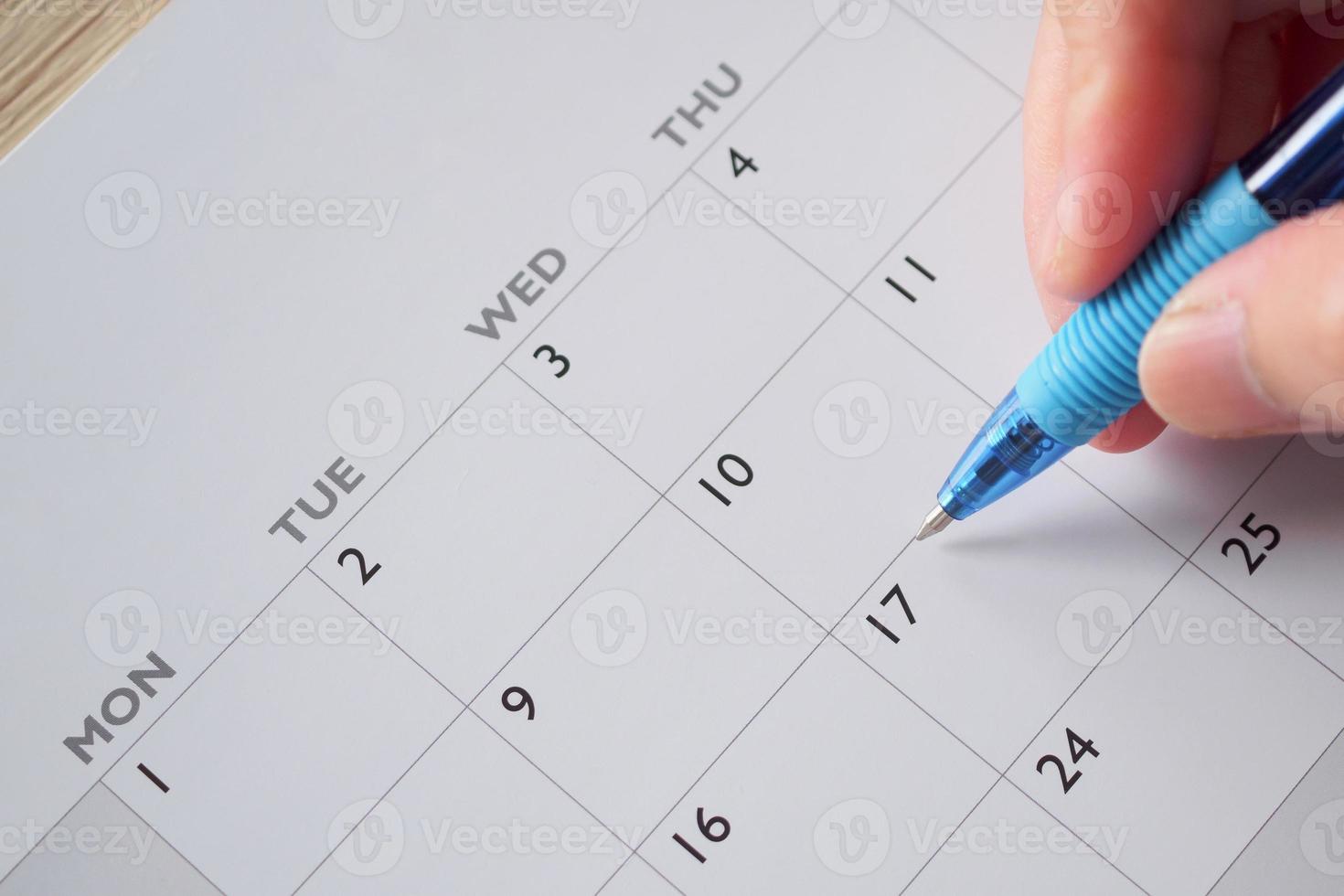 donna mano con penna scrittura su calendario Data attività commerciale pianificazione appuntamento incontro concetto foto