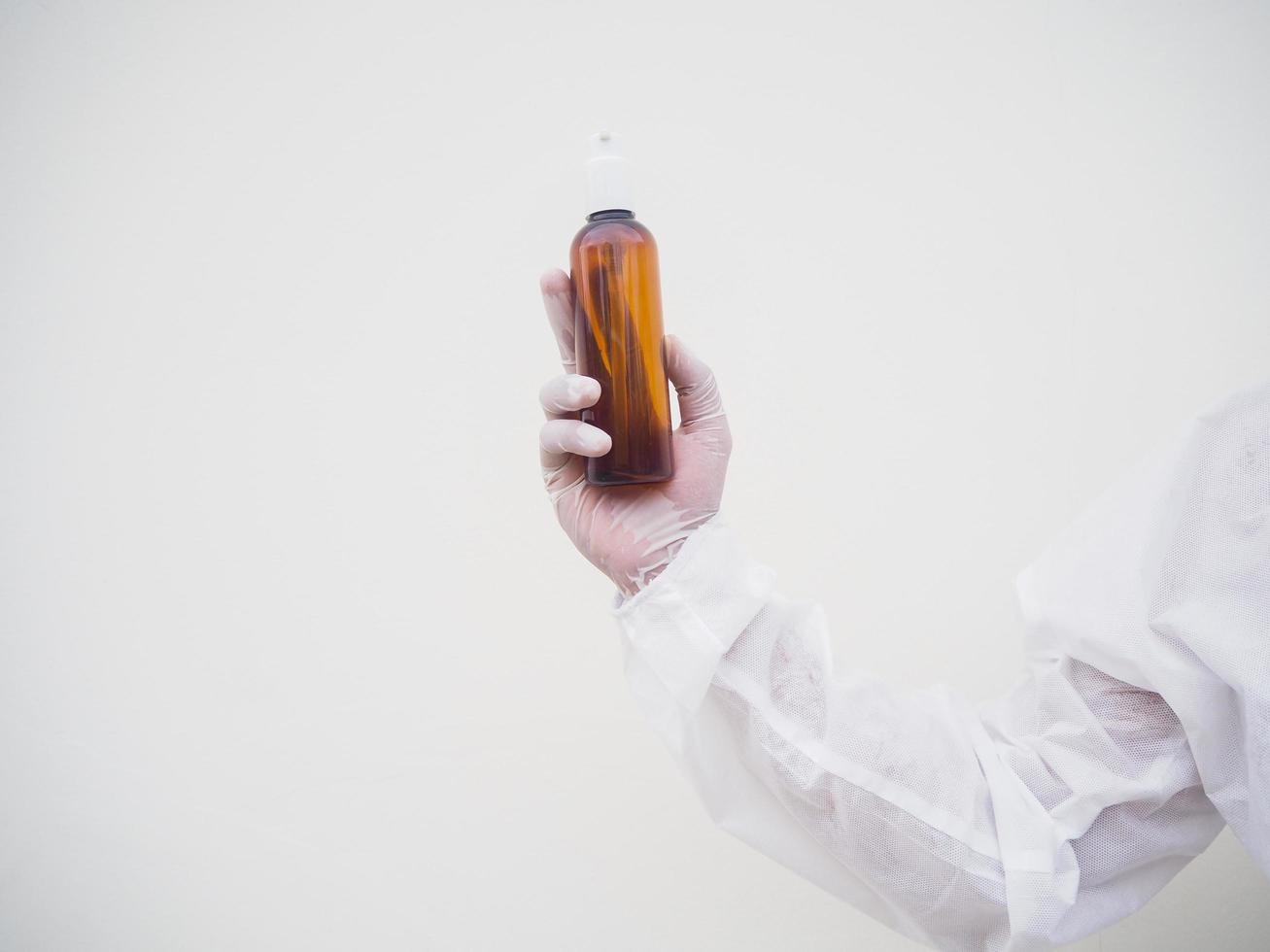 ritratto di medico o scienziato nel ppe suite uniforme Tenere plastica bottiglia con pelle cura Prodotto. covid-19 concetto isolato bianca sfondo foto