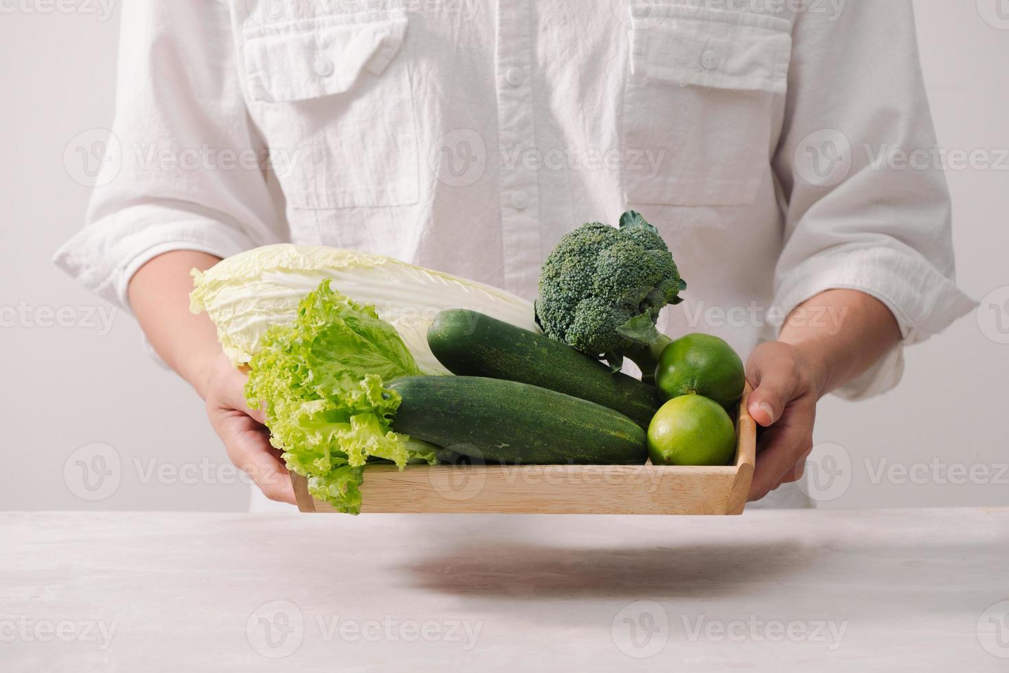 mercato. salutare vegano cibo. fresco la verdura, frutti di bosco, verdura e frutta nel di legno vassoio cetrioli ravanello verde piselli ... bianca tavolo. nel uomo mani copia spazio foto