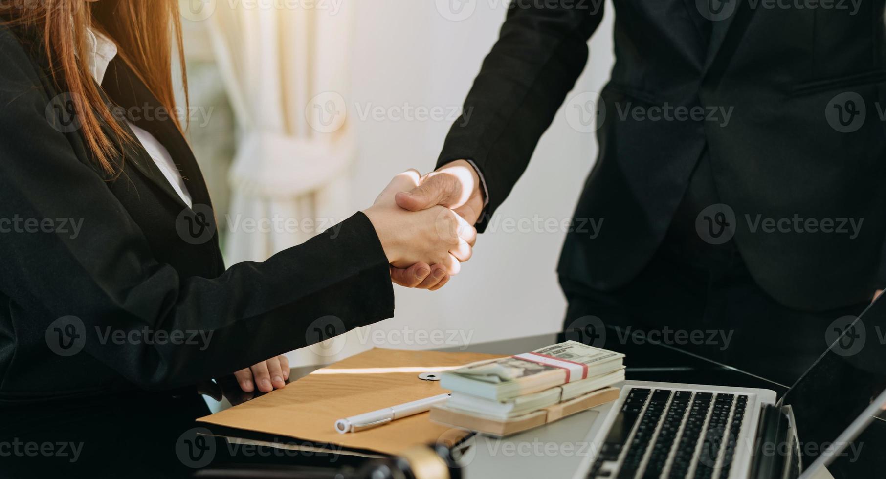 stretta di mano di affari che chiude un affare con la sfocatura dello sfondo delle persone foto