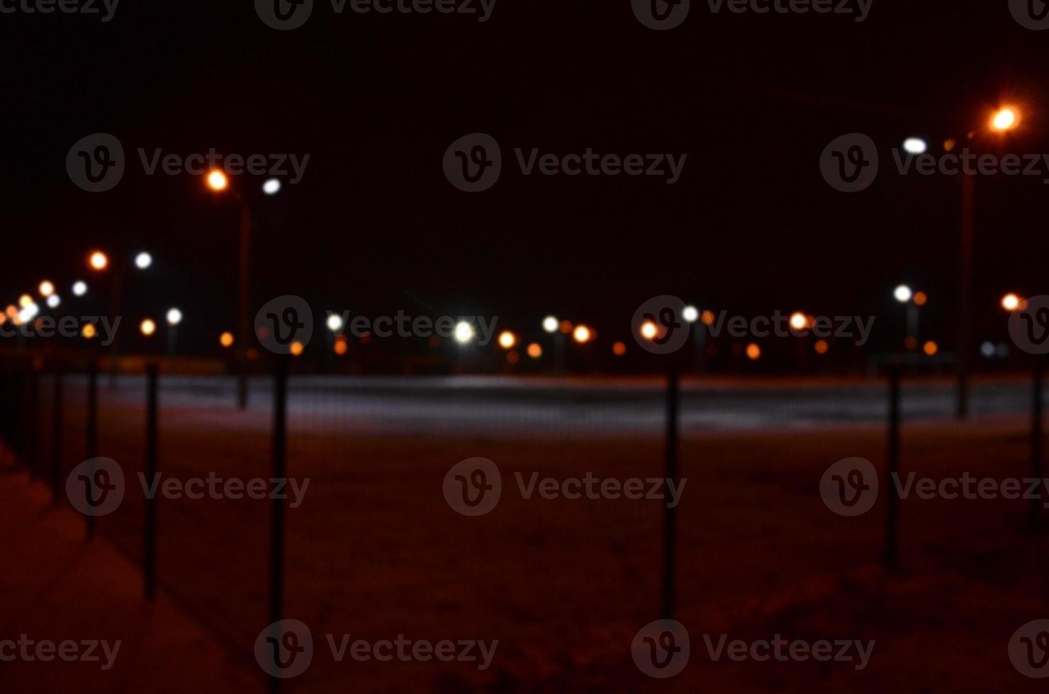 sfocato foto di scuola terreno di gioco a notte con luminosa luci