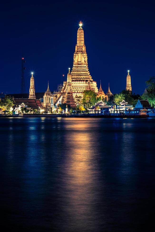 vista notturna del tempio di wat arun attraverso il fiume chao phraya a bangkok, tailandia. foto