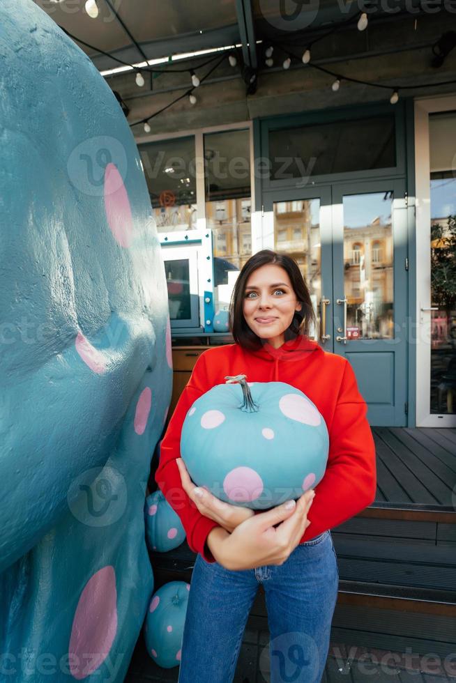 giovane donna Tenere un' blu zucca foto