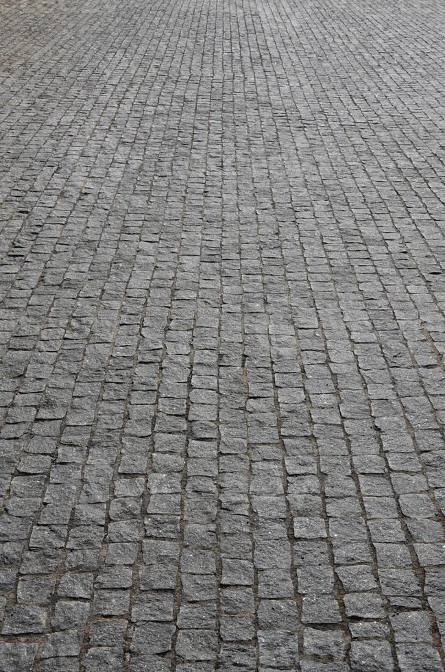 il struttura di il pavimentazione lastra pavimentazione pietre di molti piccolo pietre di un' piazza forma sotto luminosa luce del sole foto