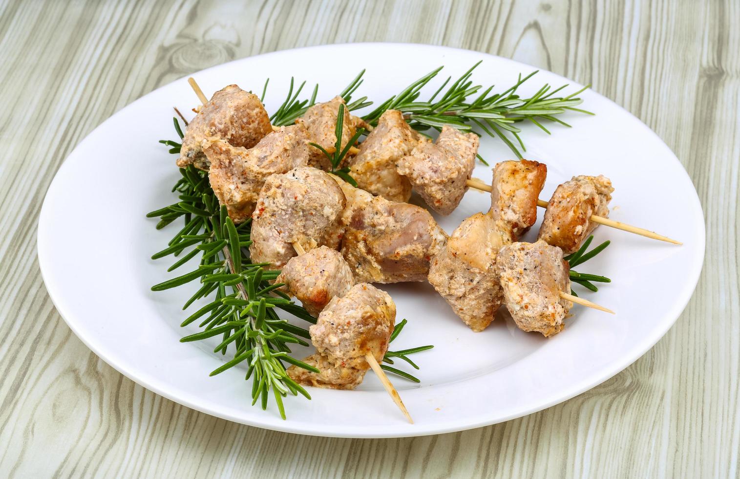 pollo spiedini su il piatto e di legno sfondo foto