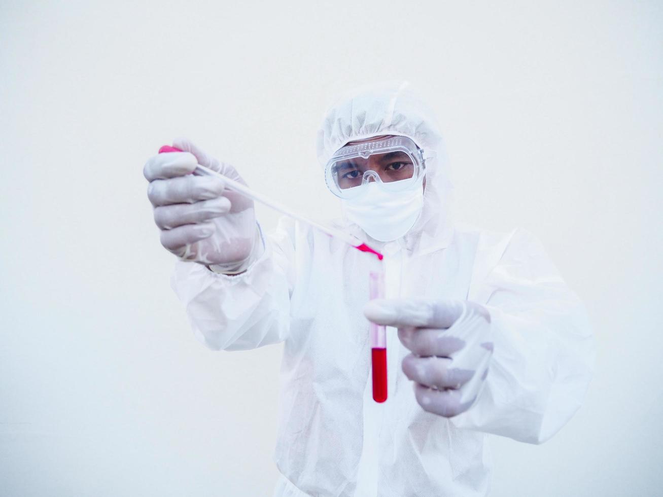 asiatico medico o scienziato nel ppe suite uniforme. personale protettivo attrezzatura completo da uomo lancio un' sangue in sangue test tubo. coronavirus o covid-19 concetto isolato bianca sfondo foto