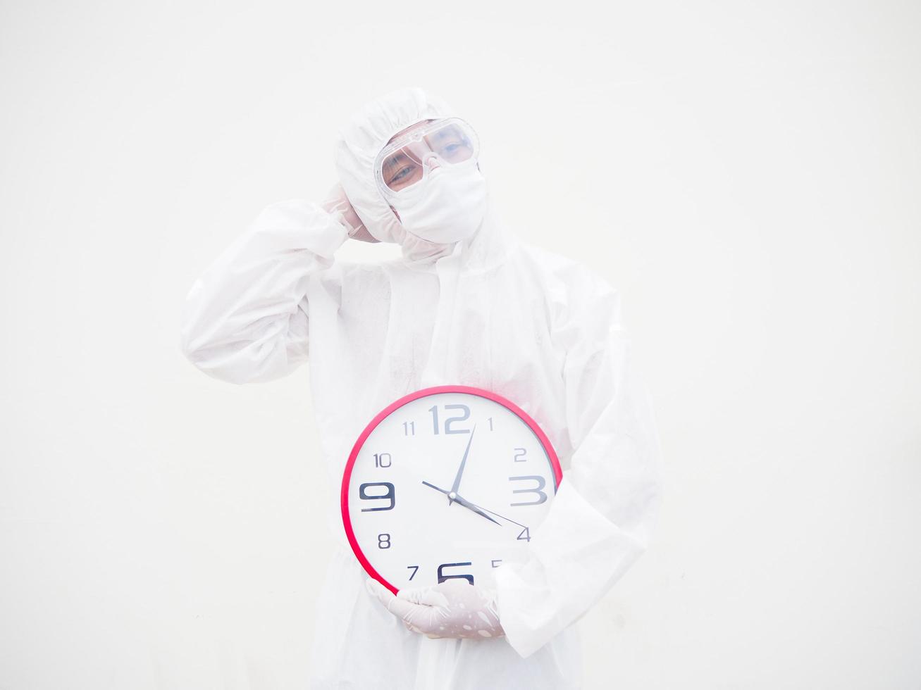 ritratto di medico o scienziato nel ppe suite uniforme Tenere rosso allarme orologio e guardare per il sinistra nel vario gesti. covid-19 concetto isolato bianca sfondo foto