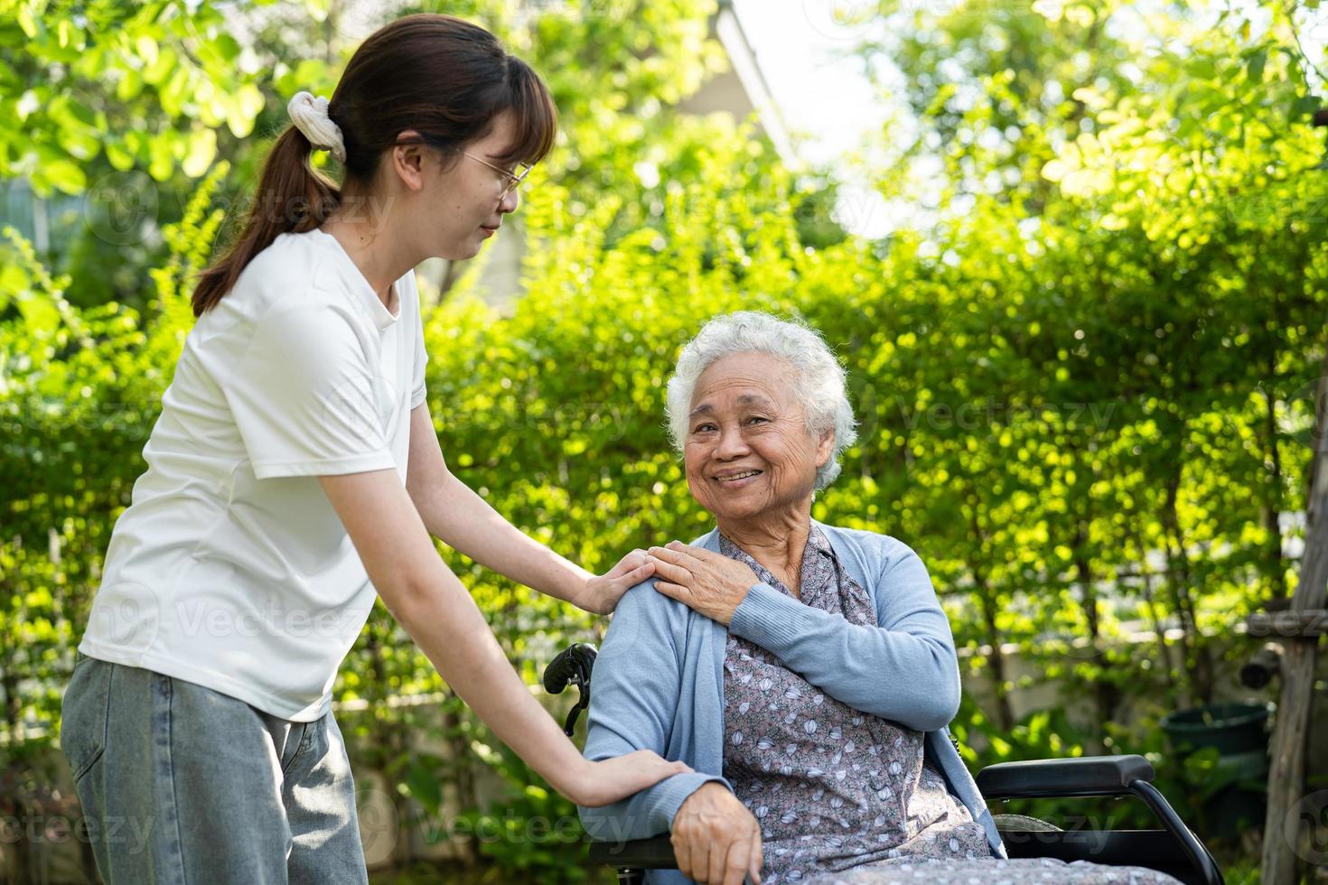 assistenza e cura del caregiver paziente asiatico anziano o anziano della donna che si siede sulla sedia a rotelle nel parco, concetto medico forte sano. foto
