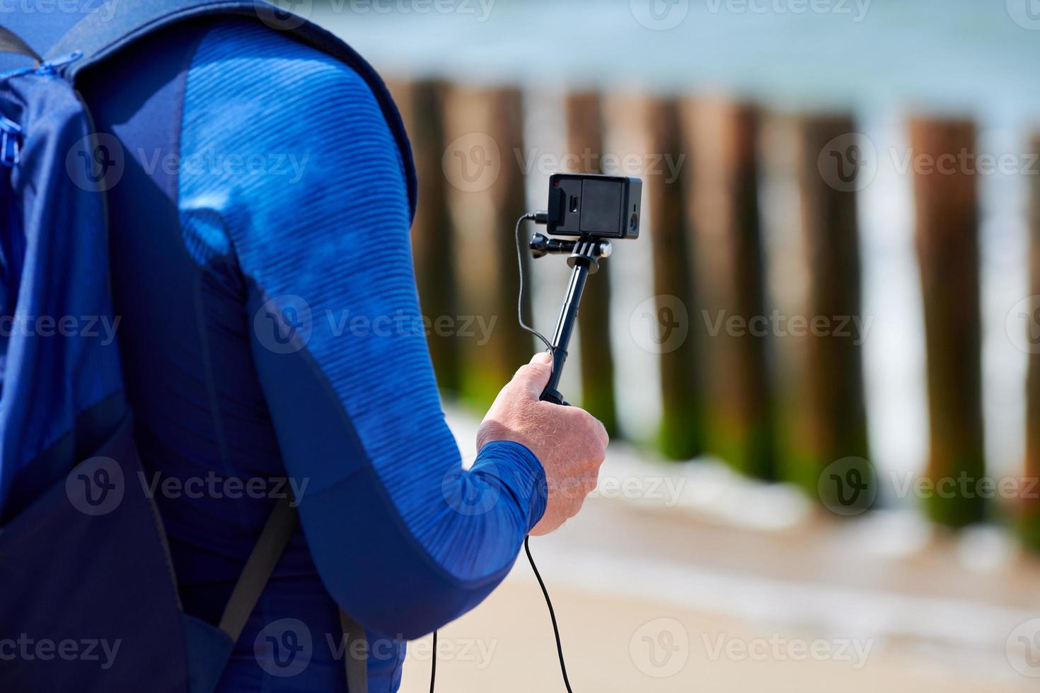 maschio turista registrazione video su azione video telecamera, mano Tenere digitale telecamera, vicino su foto