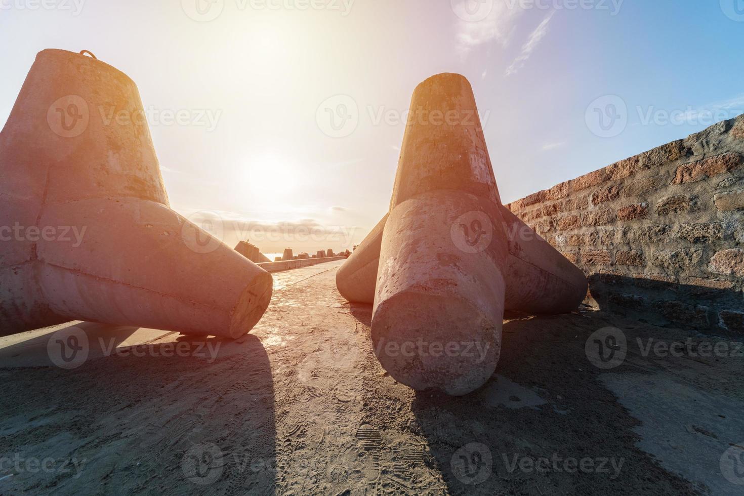 frangiflutti su molo. bellissimo tramonto paesaggio marino con calcestruzzo tetrapodi per proteggere costiero strutture a partire dal tempesta mare onde, effetti di tempo metereologico e lungolago deriva foto