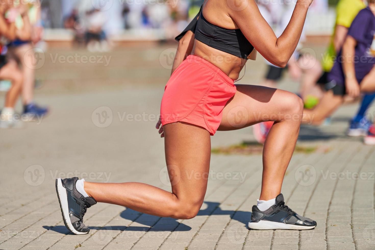 giovane donna riscaldamento su prima in esecuzione maratona foto