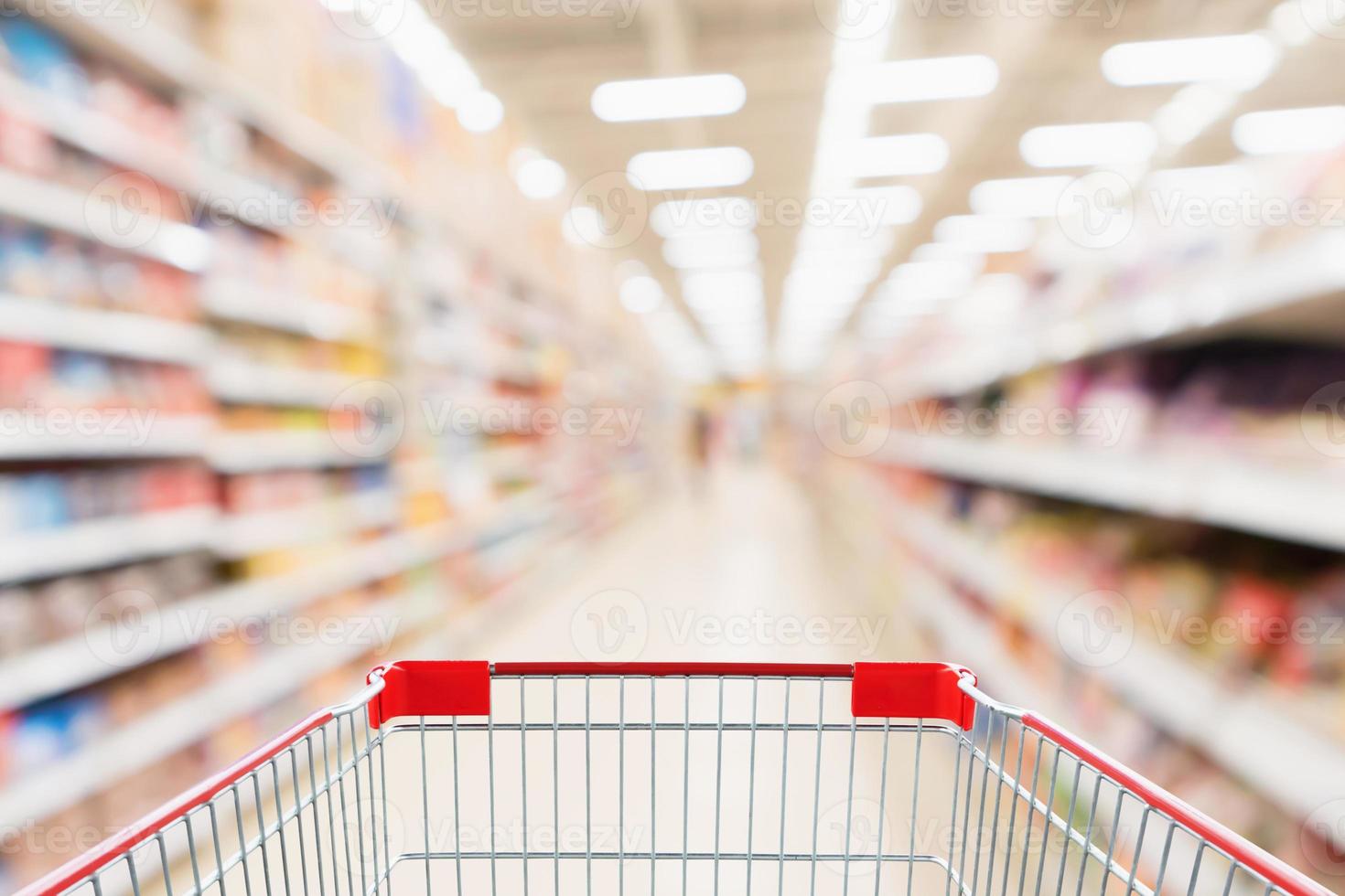 corridoio del supermercato sfondo sfocato con carrello rosso vuoto foto