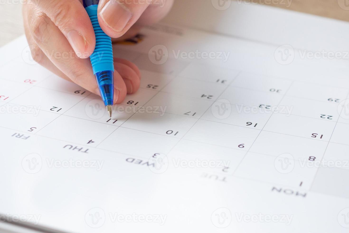 donna mano con penna scrittura su calendario Data attività commerciale pianificazione appuntamento incontro concetto foto