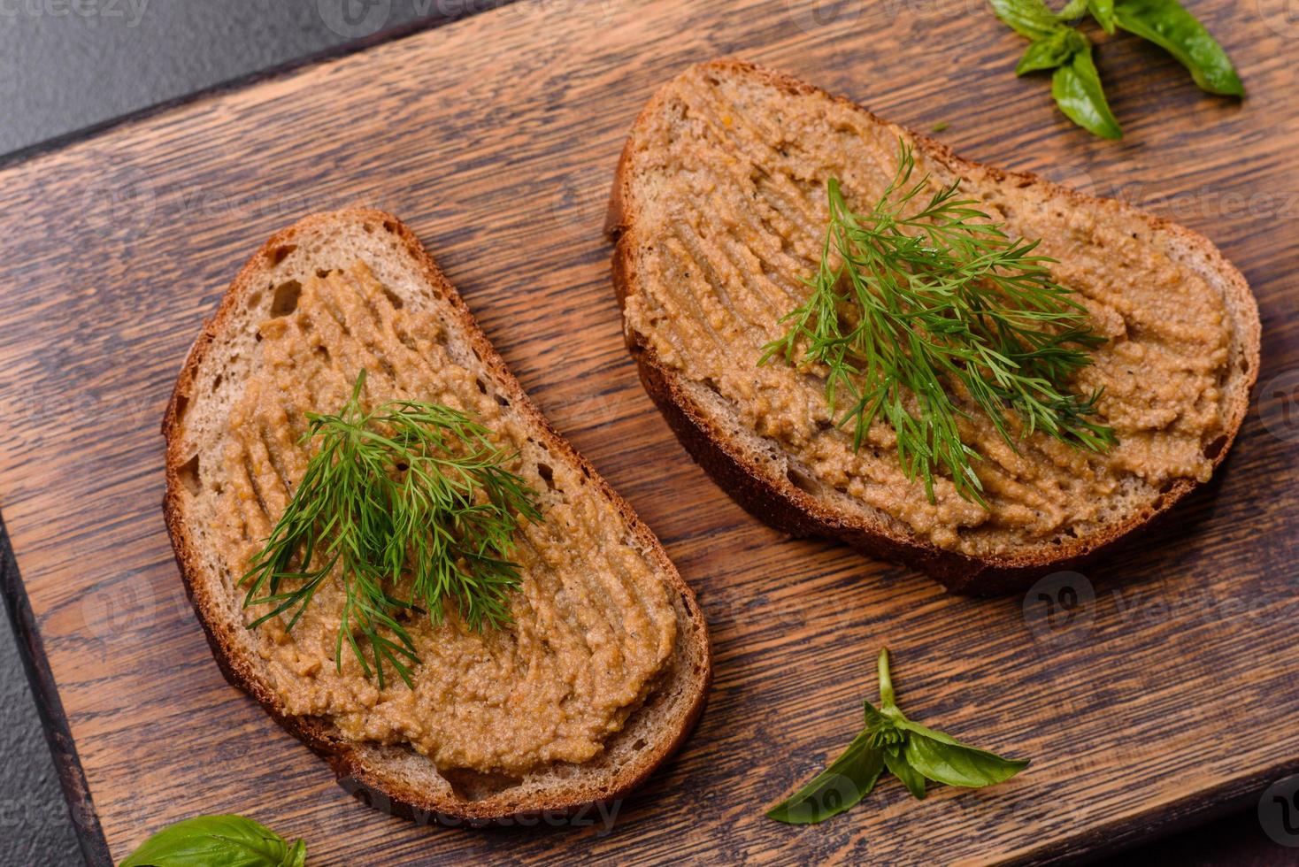 fatti in casa carne merenda fegato paté con crostini su un' buio calcestruzzo sfondo foto