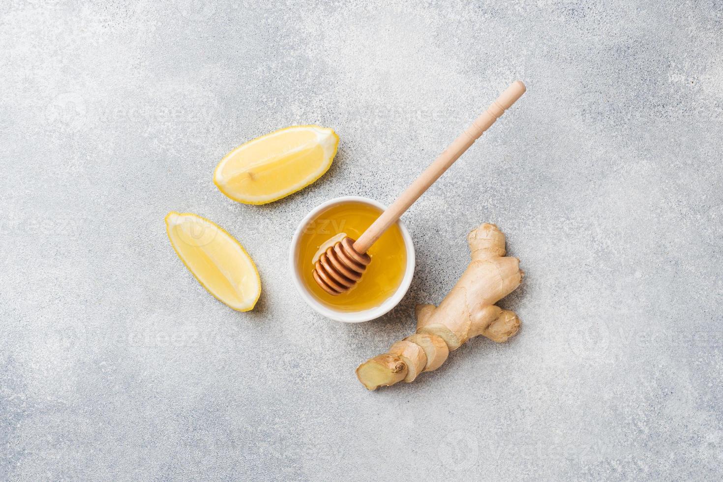Limone miele e Zenzero radice su grigio sfondo con copia spazio. ingredienti per un' Tonico vitamina bere. foto