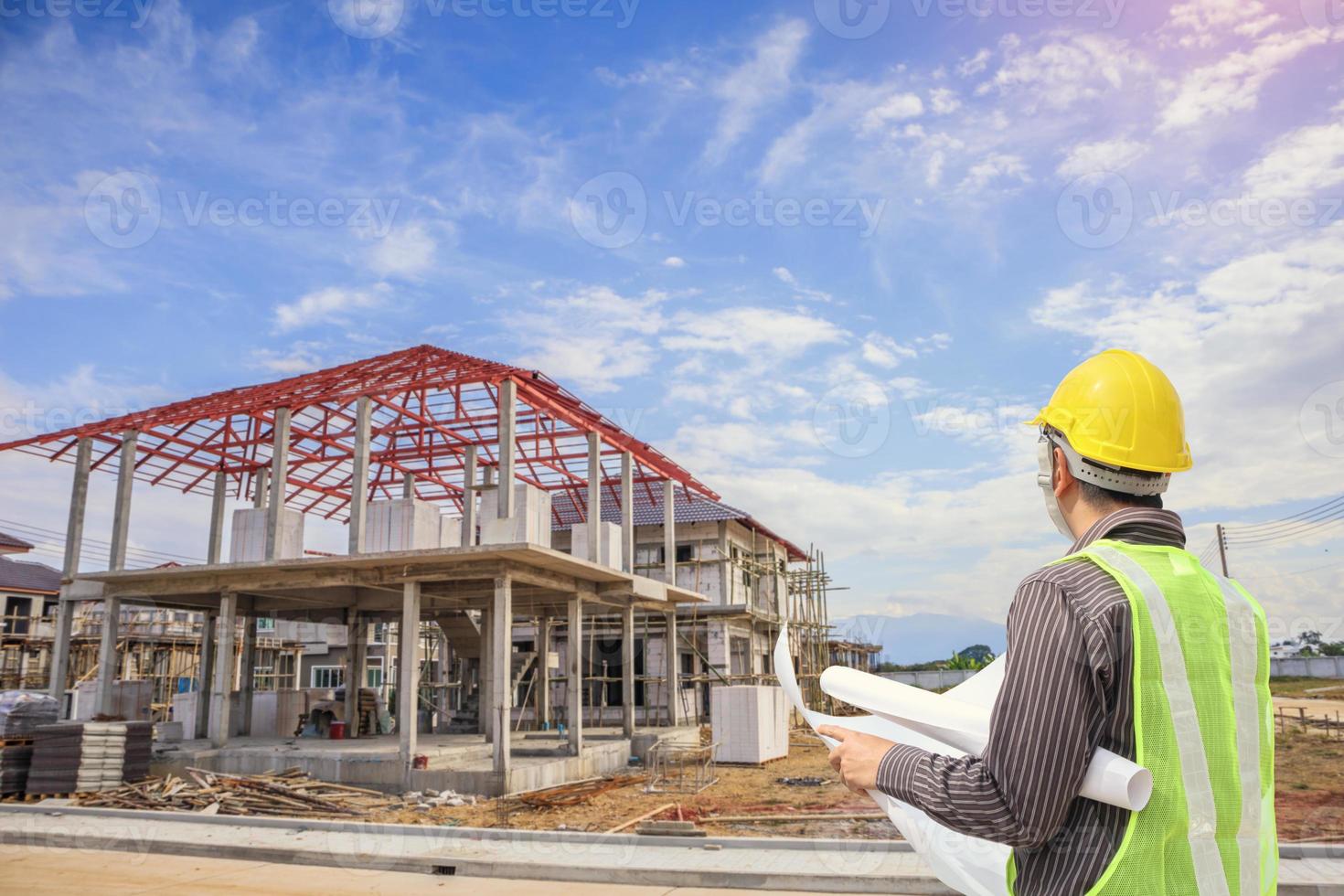 professionale ingegnere architetto lavoratore con protettivo casco e progetti carta a Casa edificio costruzione luogo foto