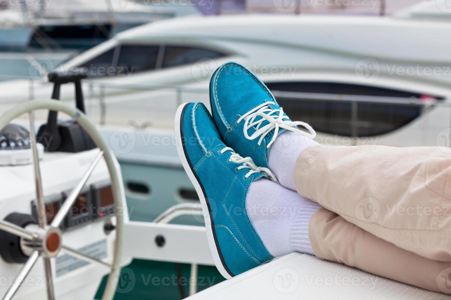 gambe nel pantaloni e luminosa blu topsider su yacht foto