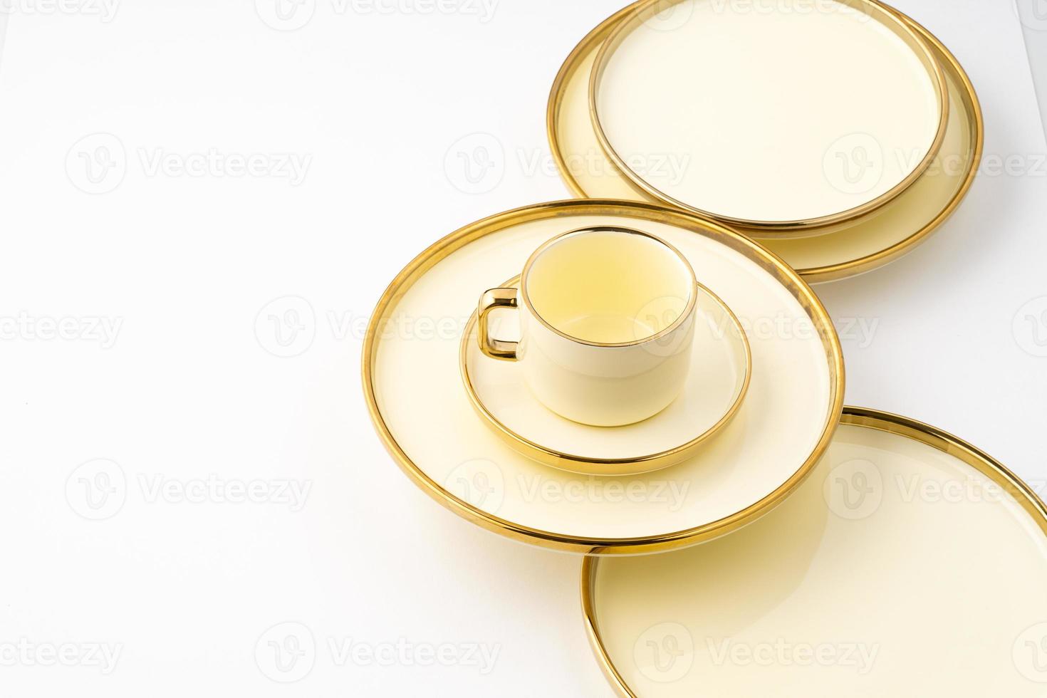 un' impostato di d'oro lusso ceramica cucina utensili su un' bianca sfondo foto