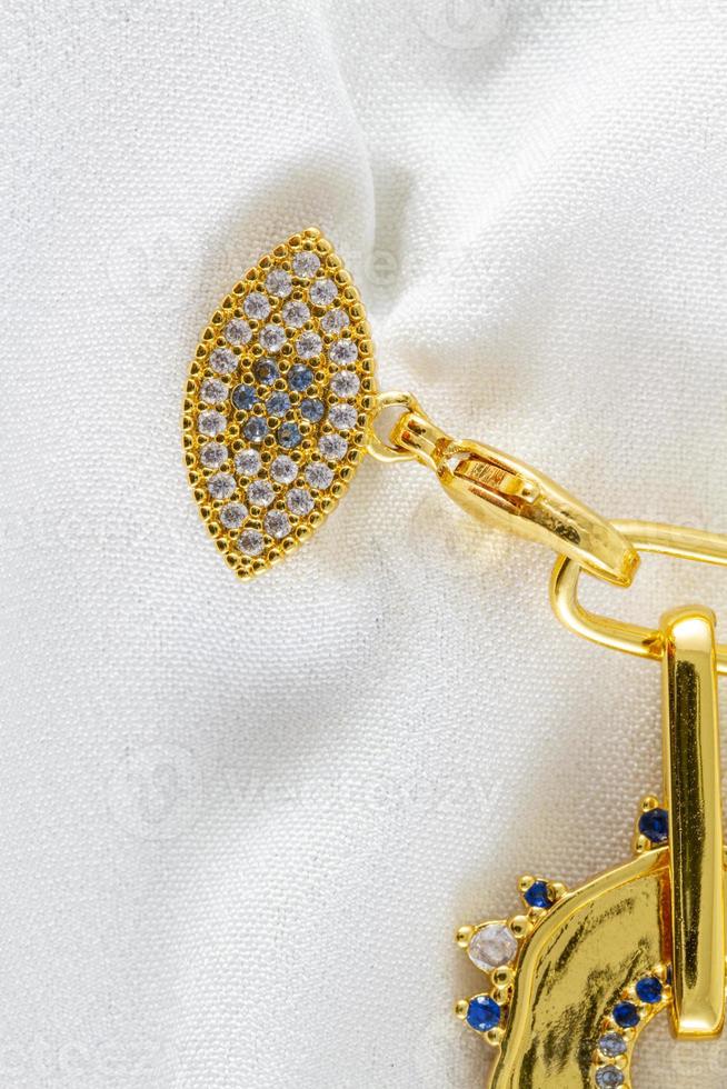 collana con protezione simbolo forma e zaffiro gemma avvicinamento su bianca foto
