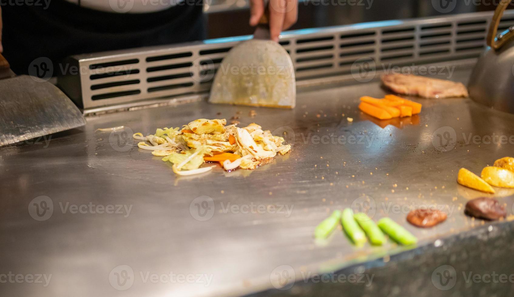 giapponese capocuoco cucinando carne nel teppanyaki ristorante foto