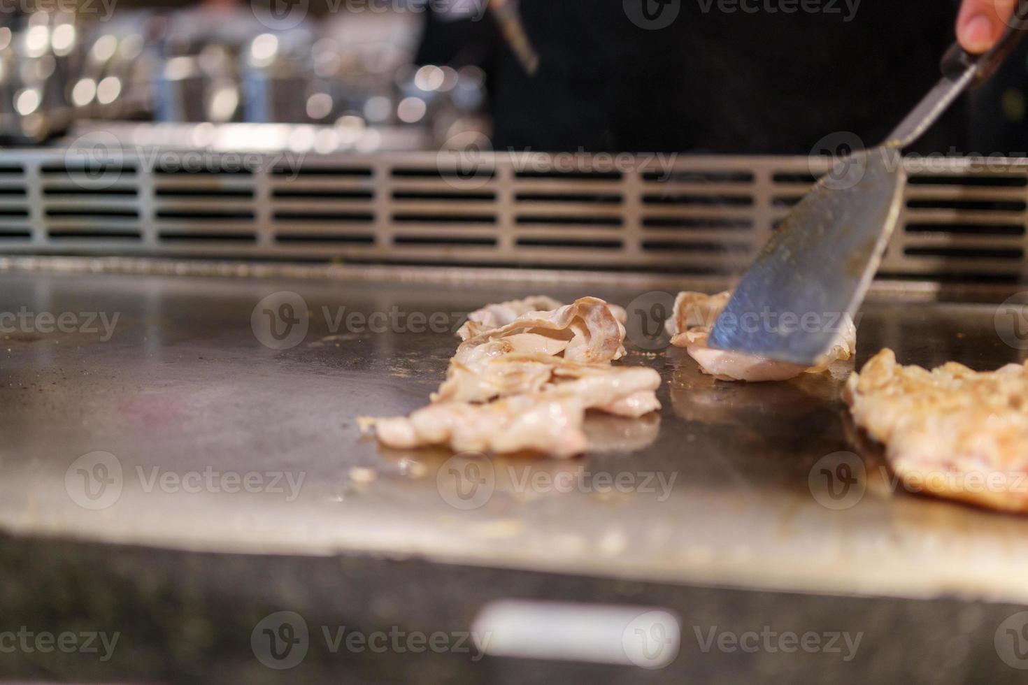 giapponese capocuoco cucinando carne nel teppanyaki ristorante foto