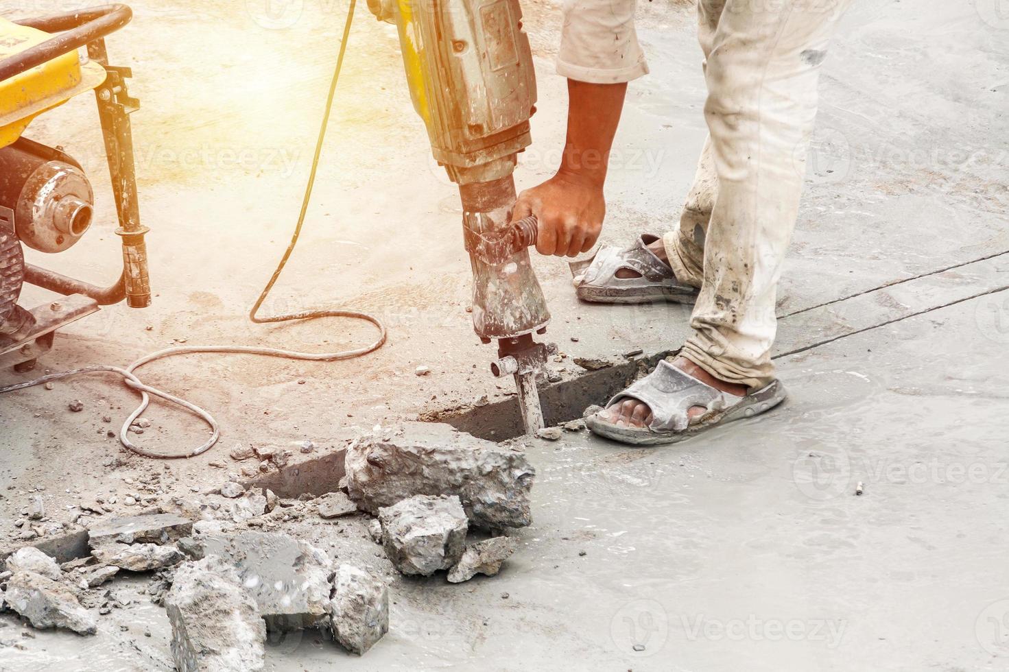 costruzione lavoratore utilizzando martello pneumatico perforazione calcestruzzo superficie foto