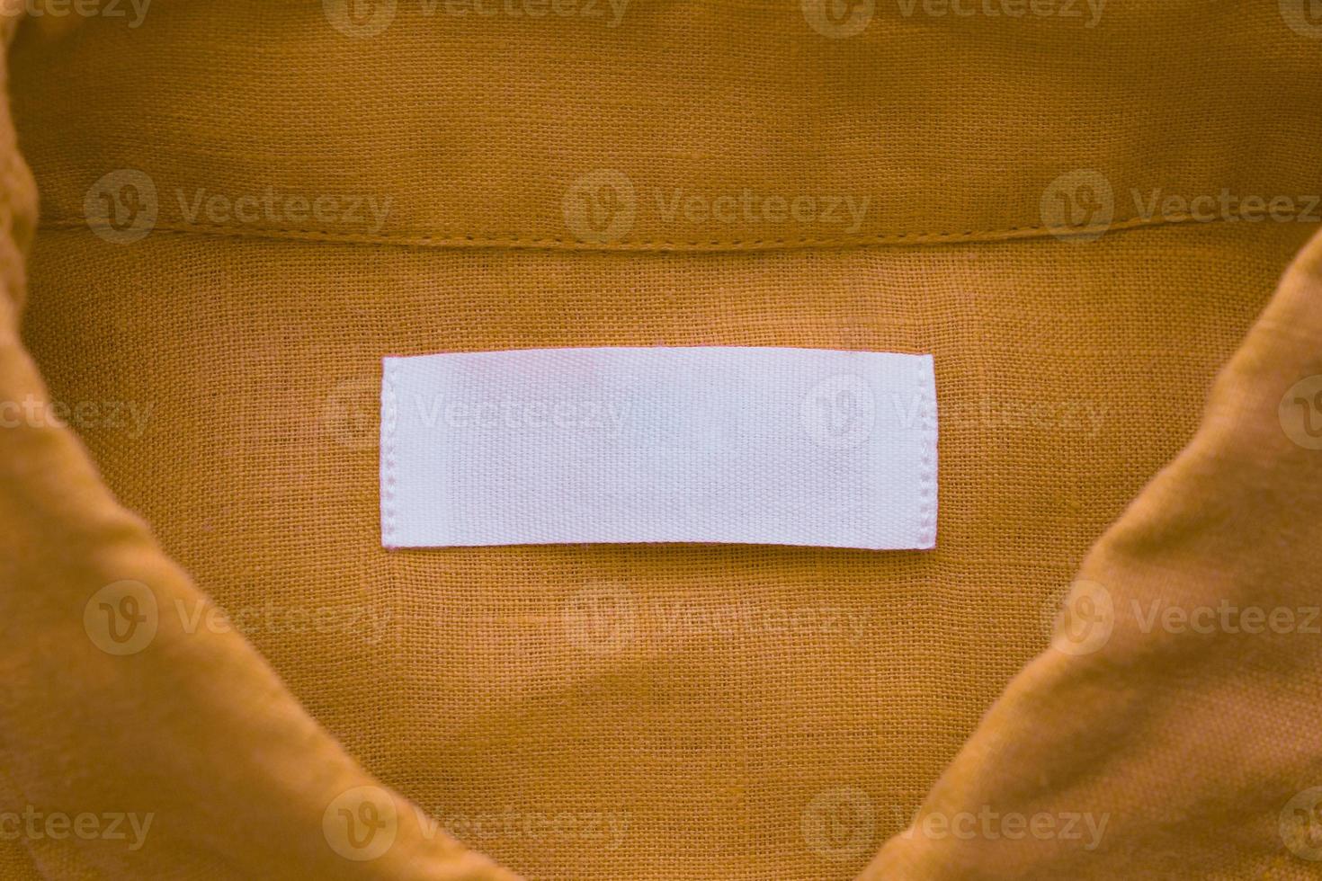 bianca vuoto capi di abbigliamento etichetta etichetta su Marrone biancheria camicia tessuto struttura sfondo foto