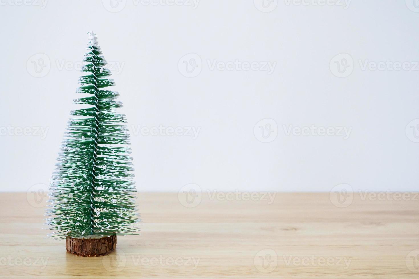 Natale albero su legna tavolo con bianca parete sfondo foto