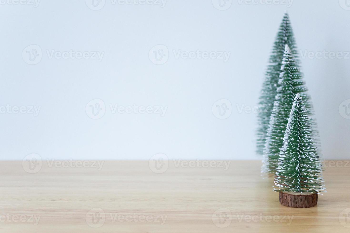 Natale albero su legna tavolo con bianca parete sfondo foto