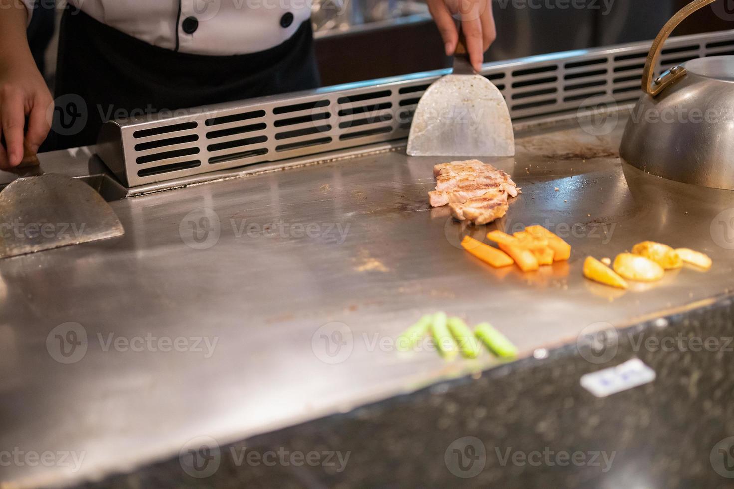 giapponese capocuoco cucinando carne nel teppanyaki ristorante foto