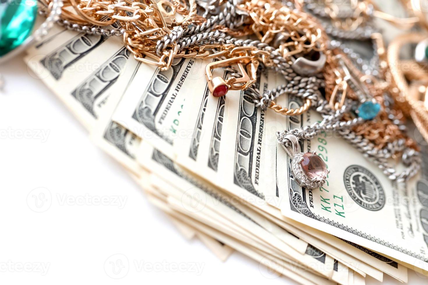 molti costoso d'oro e argento jewerly anelli, orecchini e collane con grande quantità di noi dollaro fatture su bianca sfondo. banco dei pegni o jewerly negozio foto