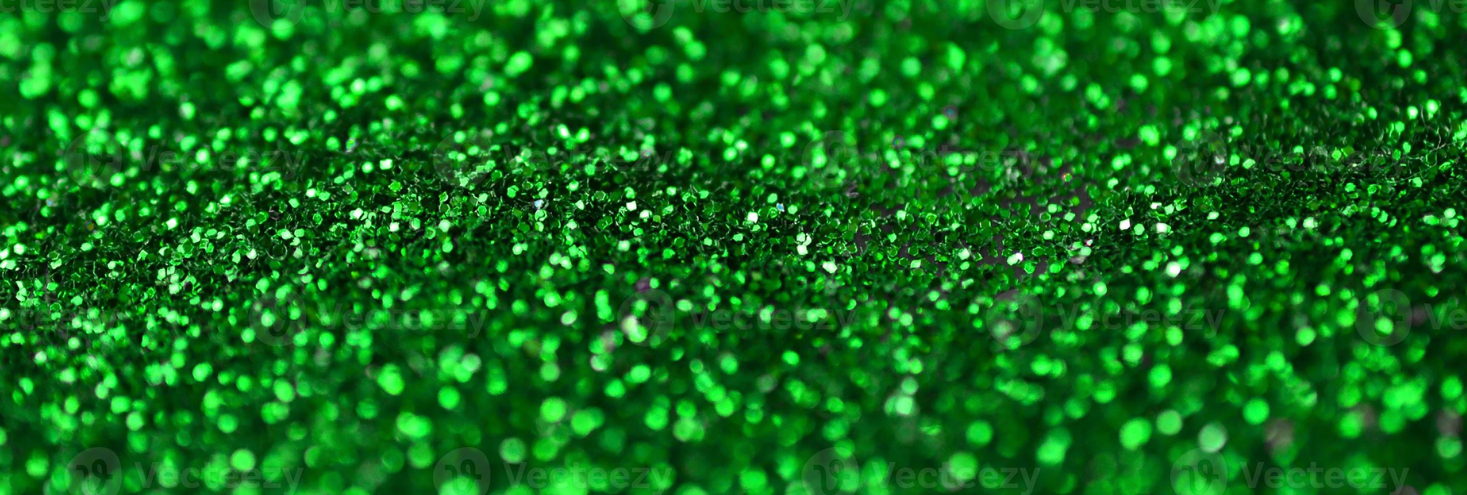 un' enorme quantità di verde decorativo paillettes. sfondo Immagine con brillante bokeh luci a partire dal piccolo elementi foto