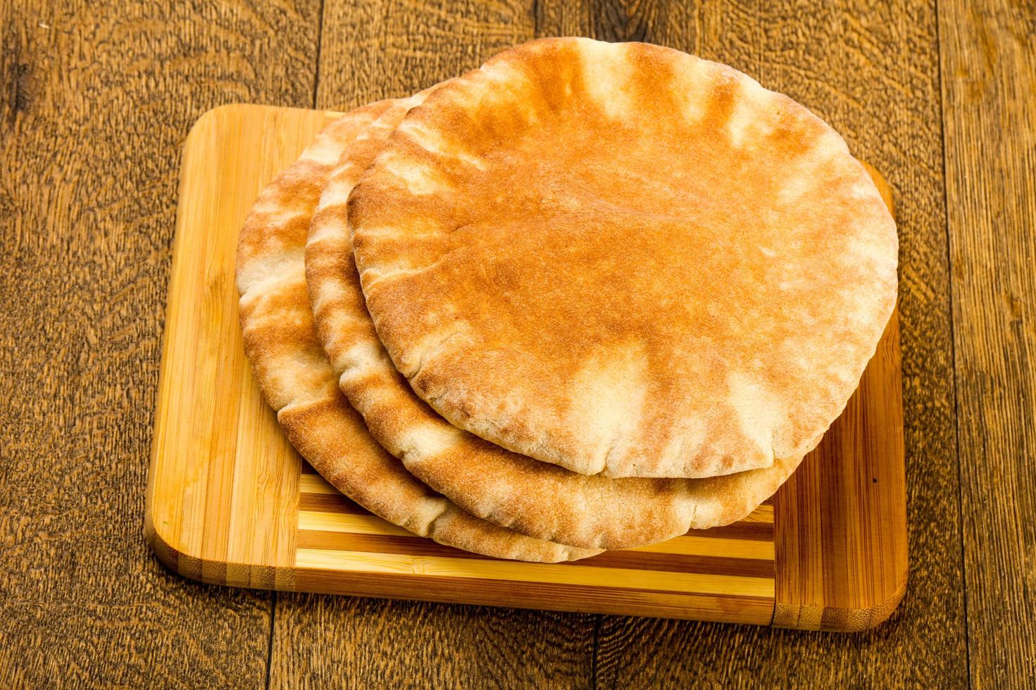 Pita pane su di legno tavola e di legno sfondo foto