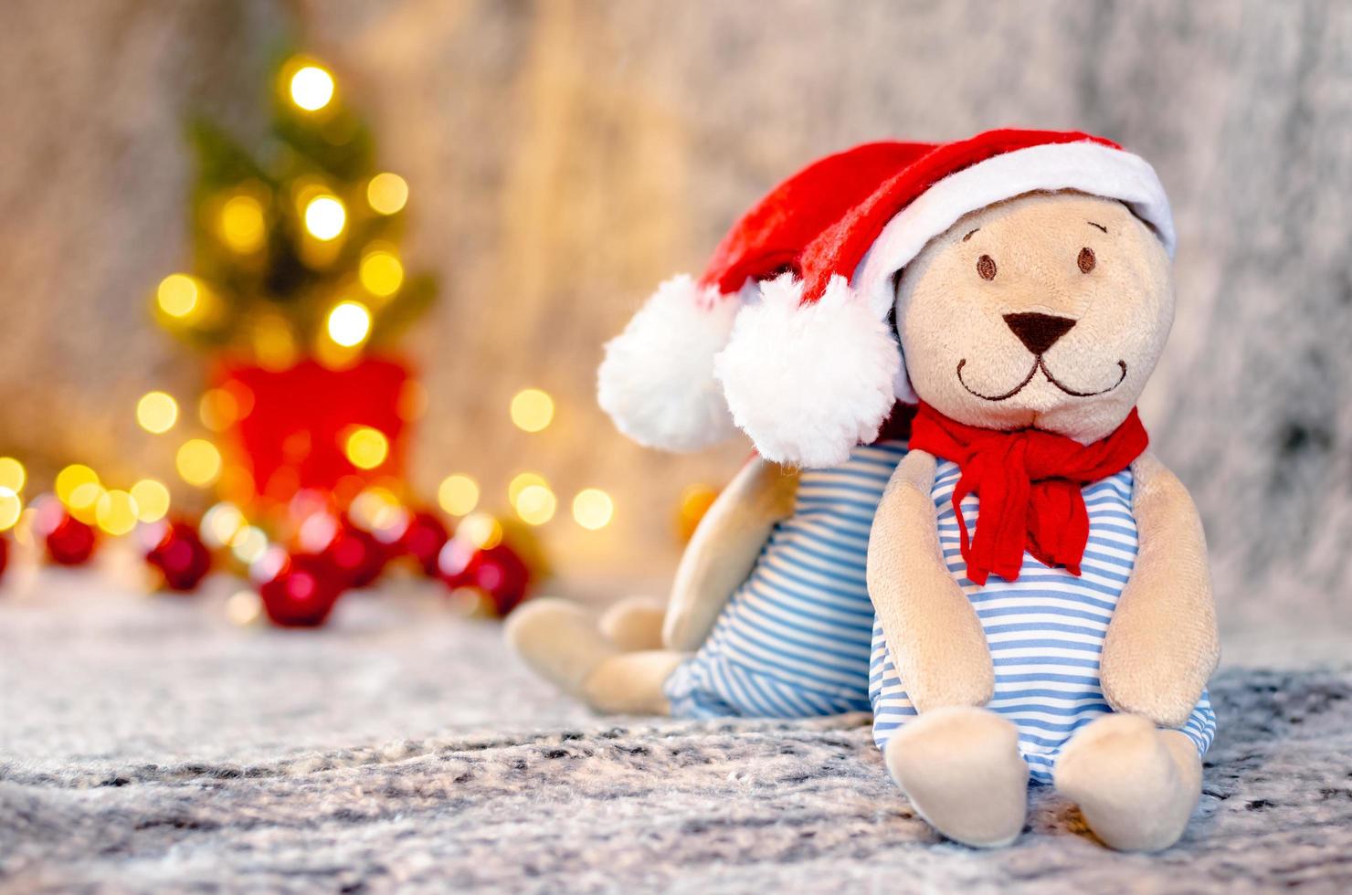 orsacchiotto orso Bambola indossare Santa cappello e sciarpa con bokeh leggero sfondo di Natale albero. foto