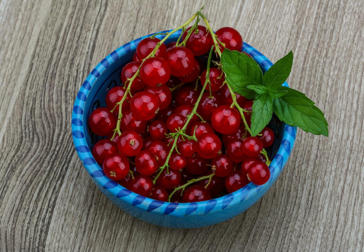 rosso ribes nel un' ciotola su di legno sfondo foto