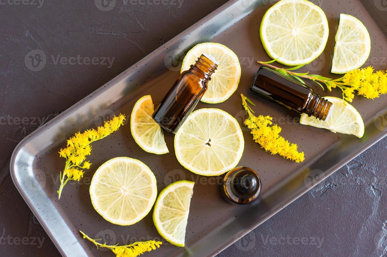 bottiglie di agrume frutta essenziale olio su un' nero sfondo e frutta fette. aromaterapia, anti stress effetto. foto