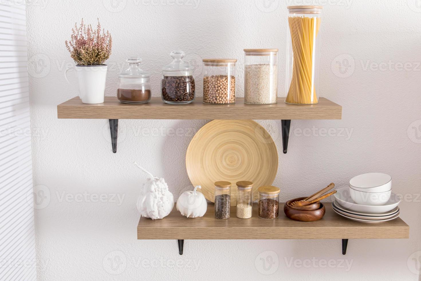 Aperto di legno scaffali con vario bicchiere barattoli con un' di legno coperchio pieno con spezie, caffè, spaghetti. elegante arredamento nel il moderno cucina. davanti Visualizza. foto