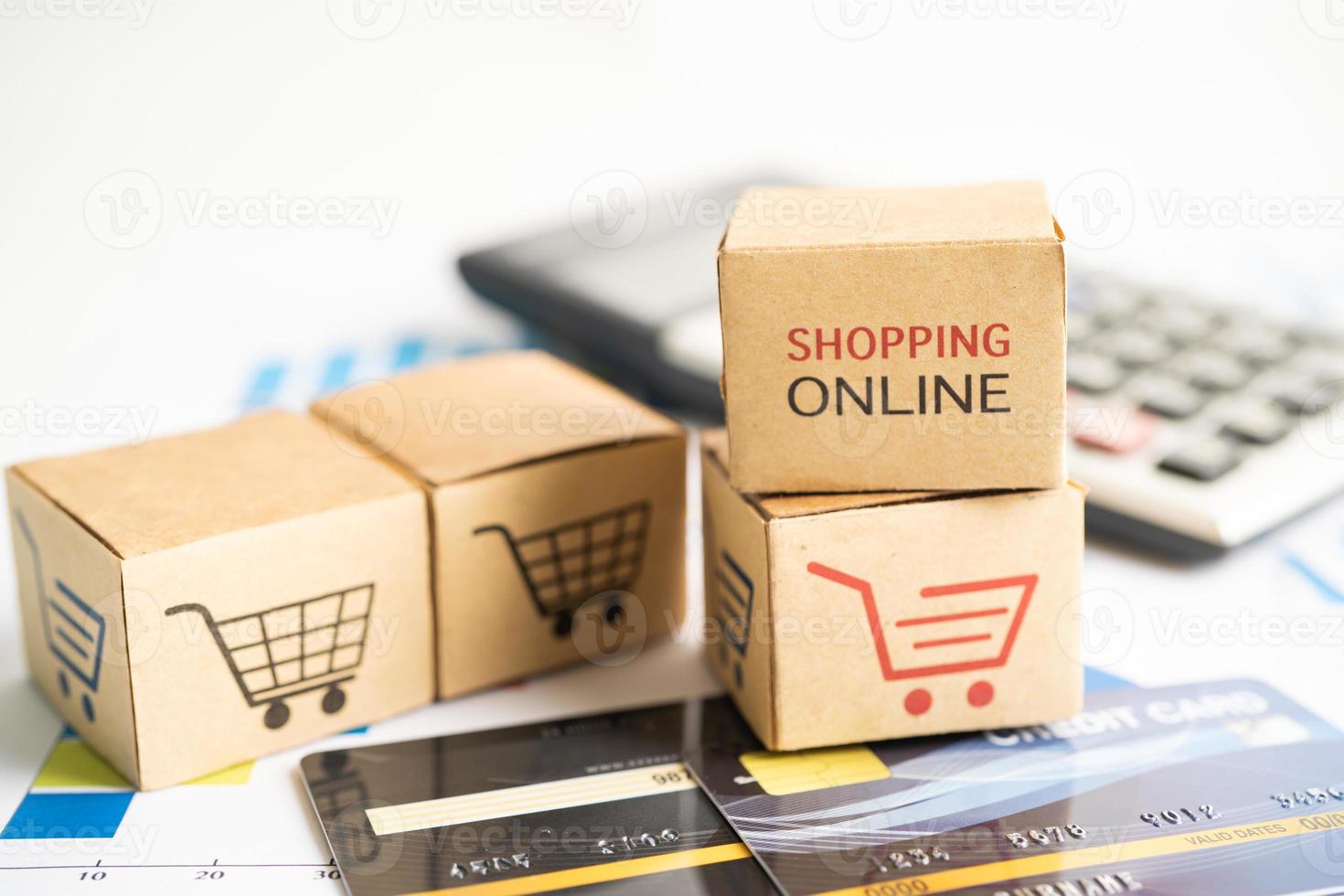 scatola di acquisto online con carta di credito e calcolatrice sul grafico. concetto di affari di importazione e esportazione di commercio finanziario. foto