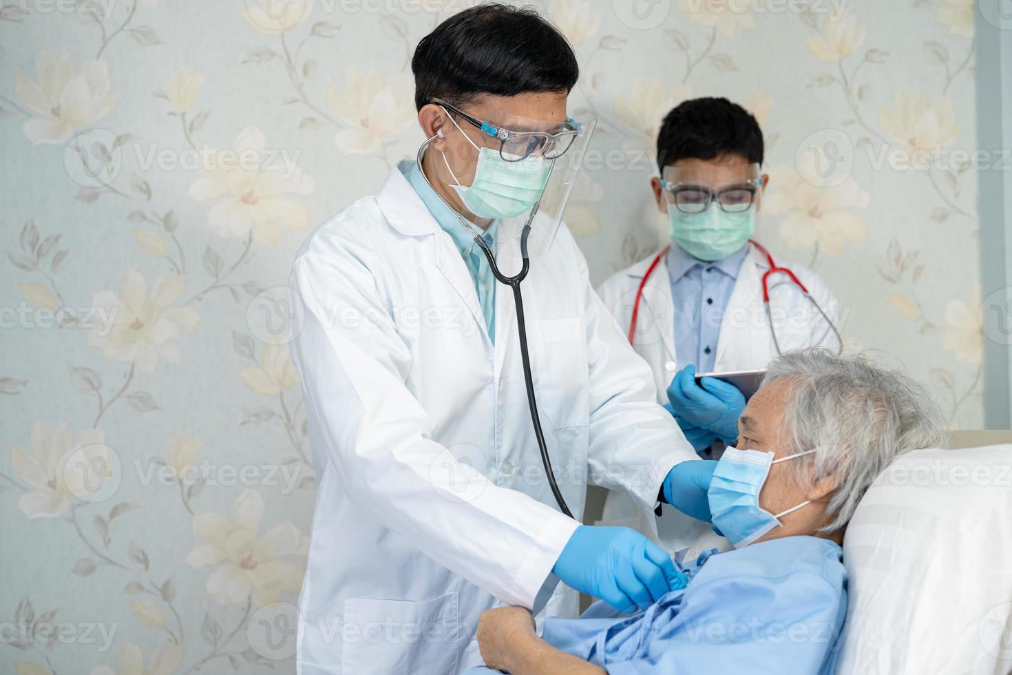 il team medico asiatico controlla il paziente anziano della signora anziana per la malattia alla motivazione nuova normalità per trattare l'infezione covid19 coronavirus nel reparto ospedaliero. foto