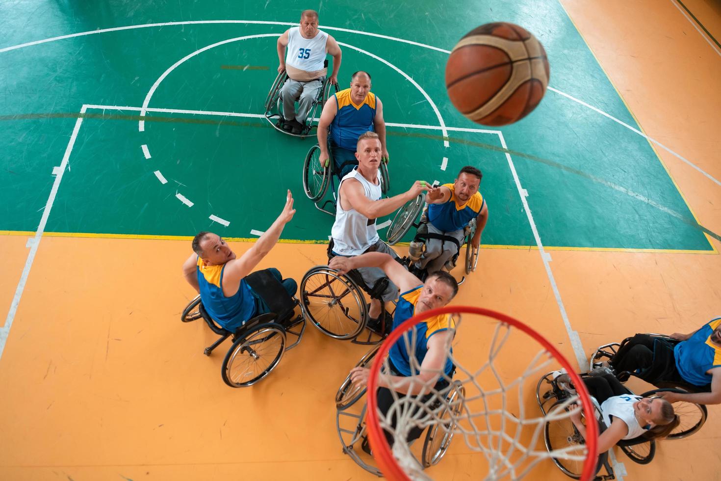 Disabilitato guerra o opera veterani misto gara e età pallacanestro squadre nel sedie a rotelle giocando un' formazione incontro nel un' gli sport Palestra sala. portatori di handicap persone reinserimento e inclusione concetto. foto