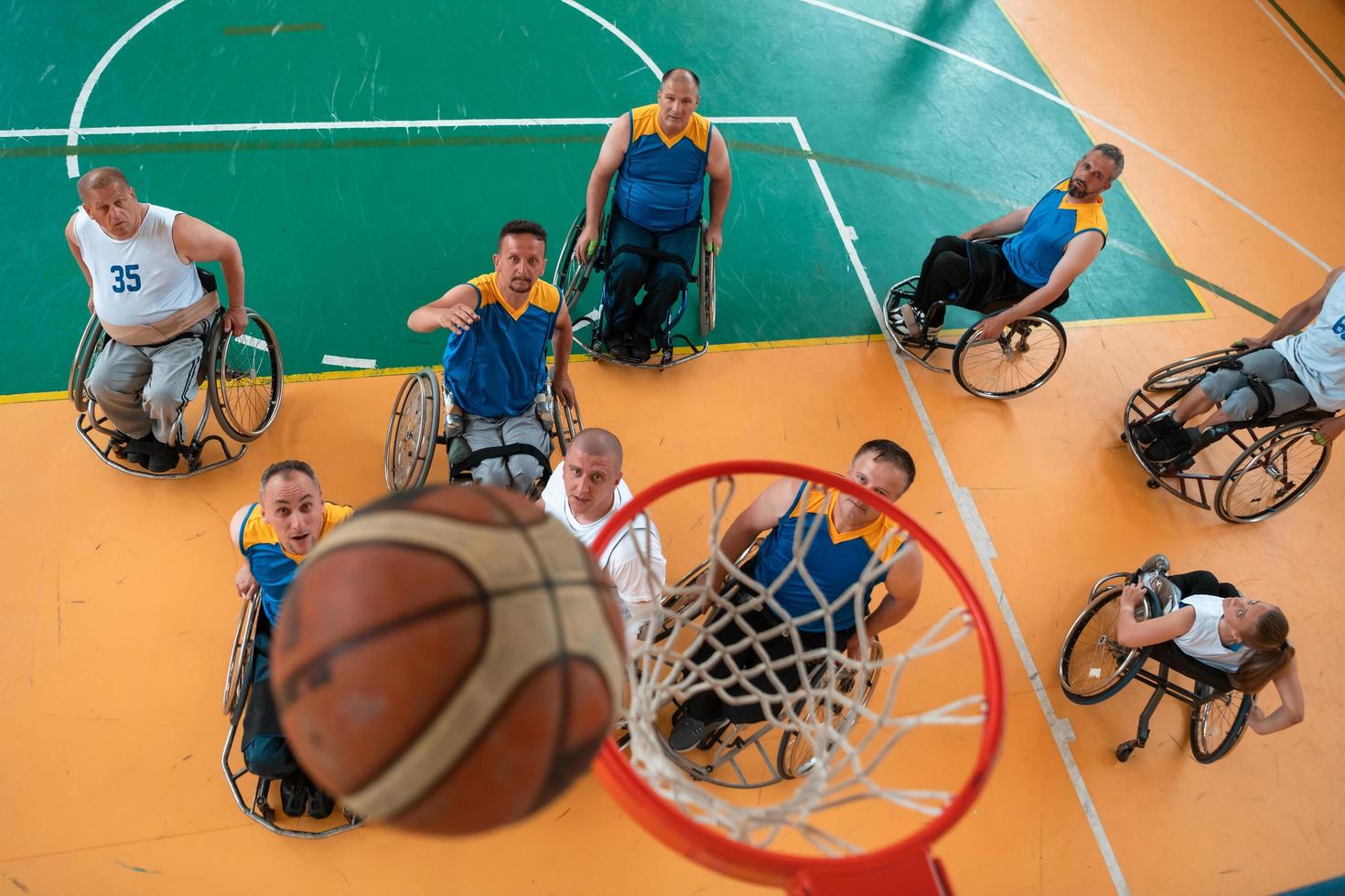 Disabilitato guerra o opera veterani misto gara e età pallacanestro squadre nel sedie a rotelle giocando un' formazione incontro nel un' gli sport Palestra sala. portatori di handicap persone reinserimento e inclusione concetto. foto