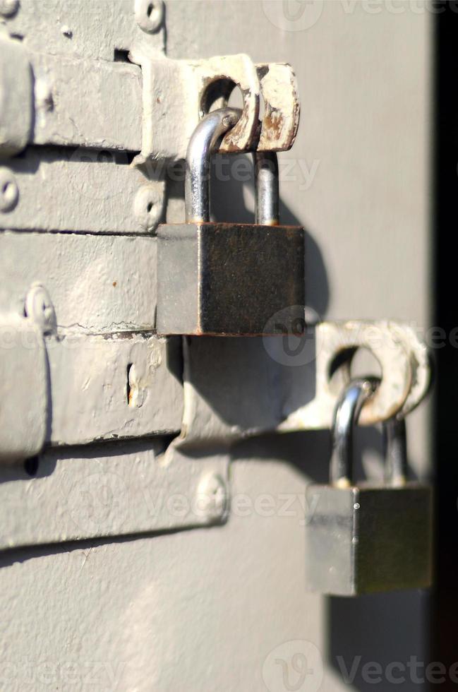 un' fotografia di il frammento è un' metallo porta con Due piazza lucchetti. selettivo messa a fuoco con superficiale profondità di campo foto