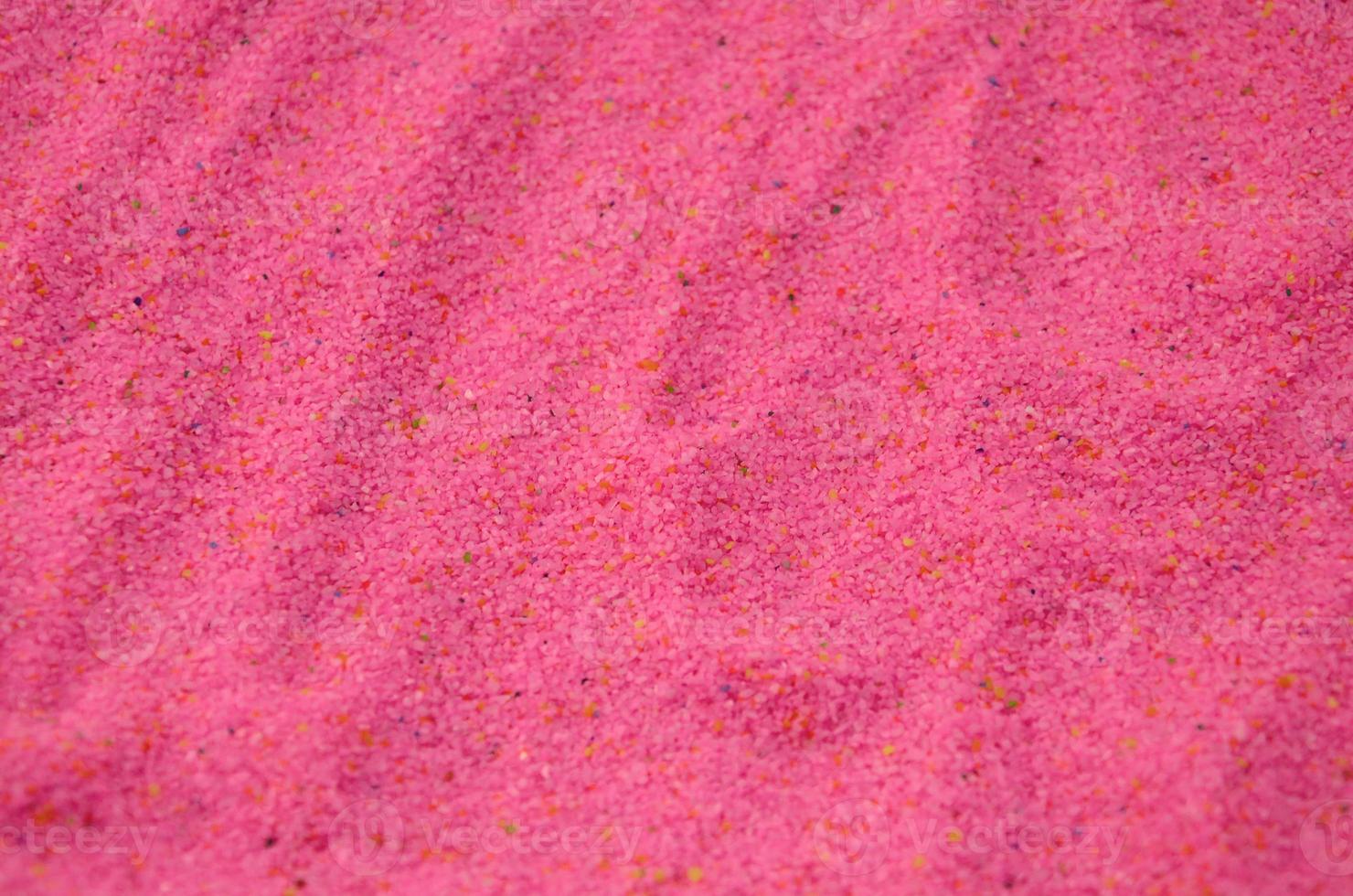 struttura di un' colorato granulare sabbia vicino su. rosa cereali foto