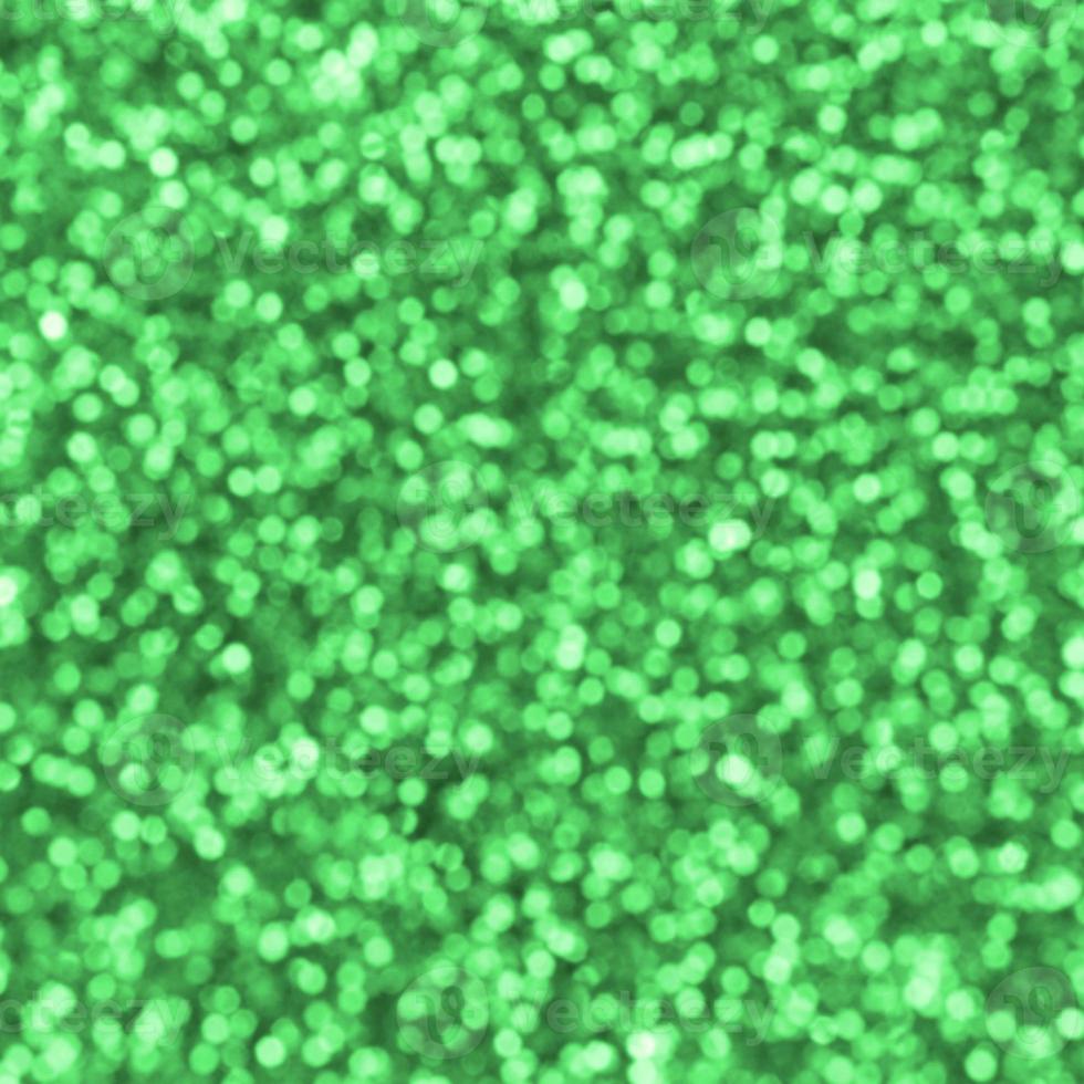 sfocato verde decorativo paillettes. sfondo Immagine con brillante bokeh luci a partire dal piccolo elementi foto