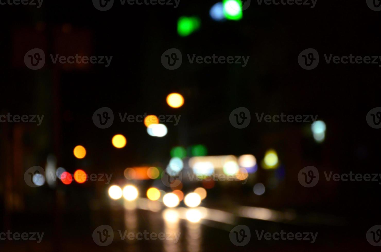 sfocato notte scena di traffico su il carreggiata. sfocato Immagine di macchine in viaggio con luminoso fari. bokeh arte foto