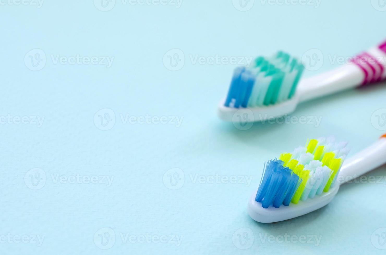 Due spazzolini da denti menzogna su un' pastello blu sfondo. superiore Visualizza, piatto posizione. minimo concetto foto