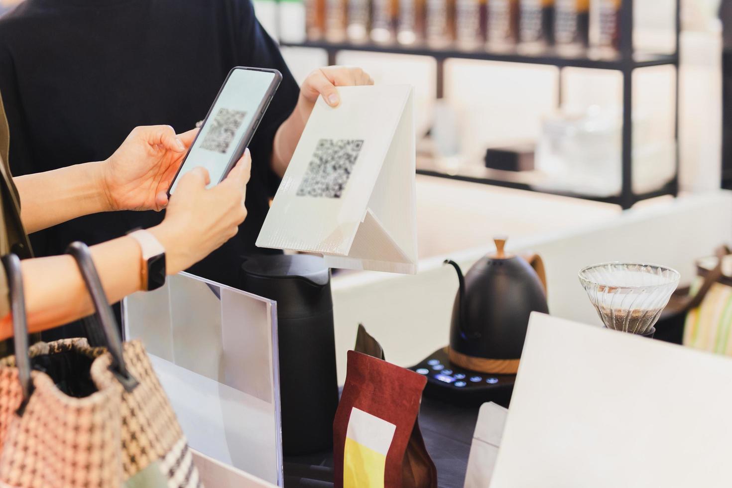 donne cliente pagare di qr codice lettura su mobile Telefono a negozio. foto